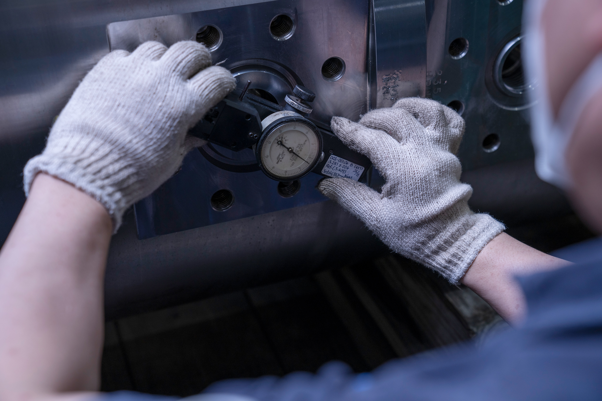 Technician checking pressure gauge on component