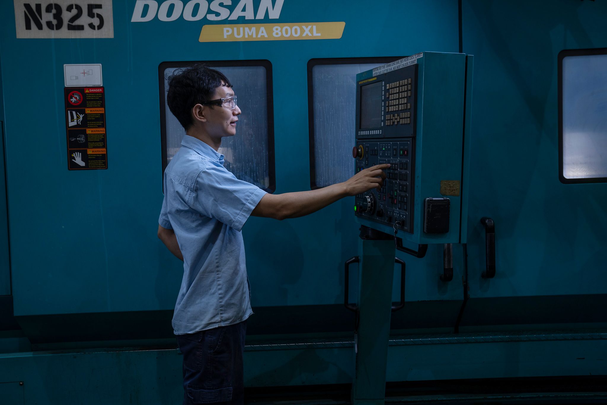 Operator using CNC machine control panel