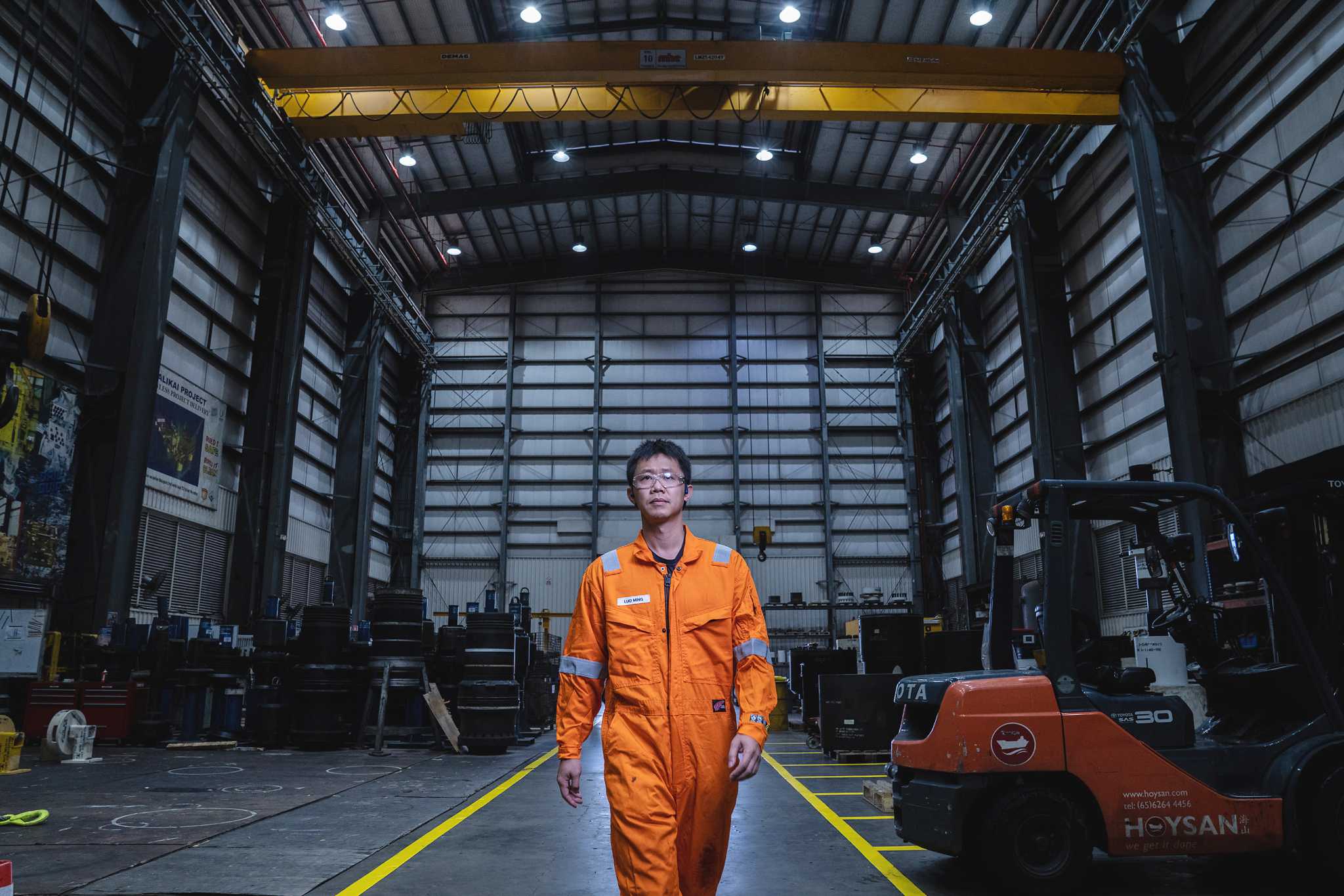 Worker standing in large warehouse aisle