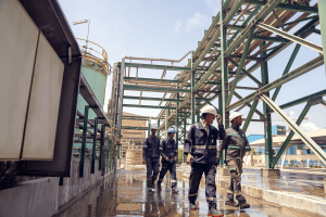 industrial photographer Workers moving along elevated walkway in a processing facility